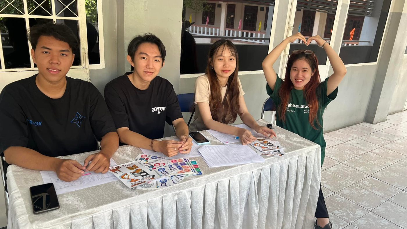 Ba bạn sinh viên FPT Jetking, ngồi bên trái, hỗ trợ check-in sự kiện